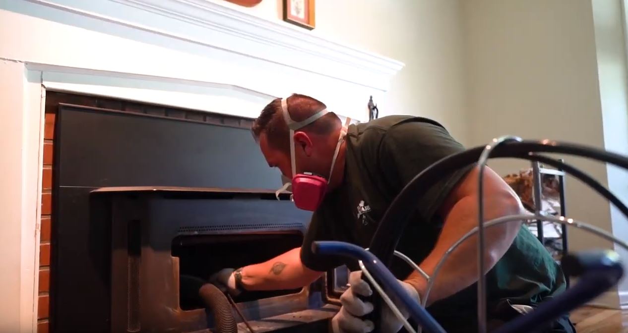 chimney sweep technician sweeping a chimney