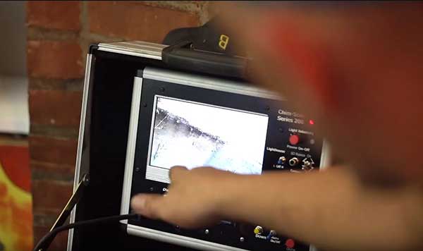 close up of technician's hand pointing to a video inspection screen
